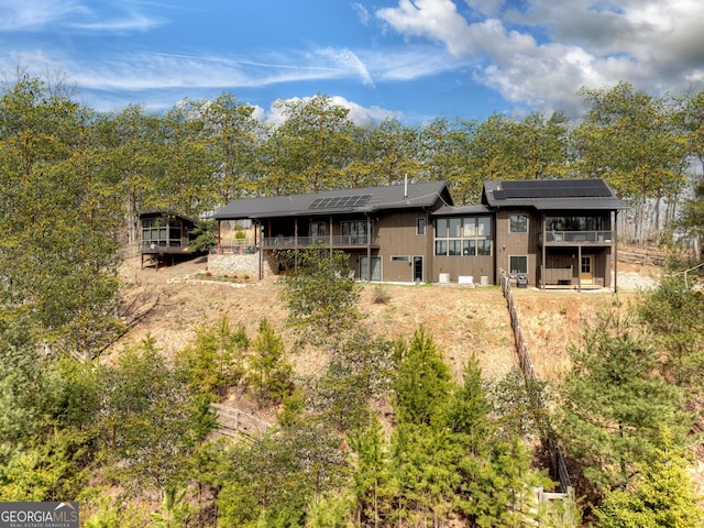 view of front of house featuring a wooden deck and roof mounted solar panels