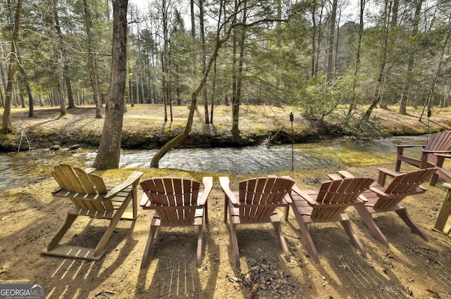 exterior space featuring a forest view and a fire pit