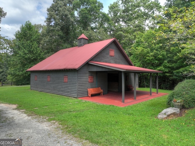 view of property exterior featuring a patio, a yard, and metal roof