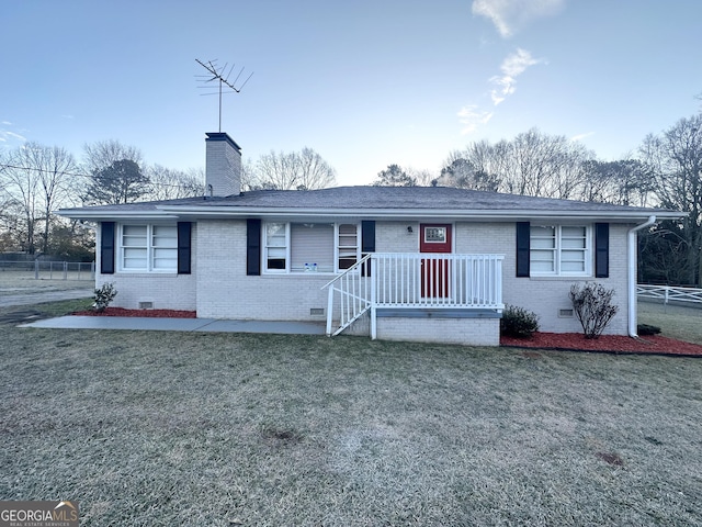 ranch-style home with fence, a chimney, a front lawn, crawl space, and brick siding