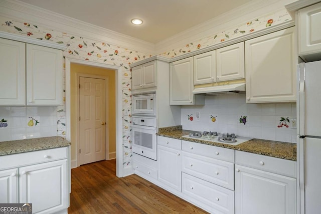 kitchen featuring white appliances, stone countertops, dark wood-style flooring, ornamental molding, and under cabinet range hood