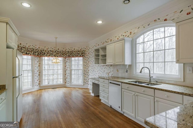 kitchen featuring white appliances, wood finished floors, crown molding, and a sink