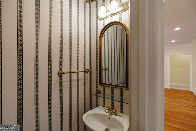 bathroom featuring recessed lighting, wood finished floors, baseboards, and a sink