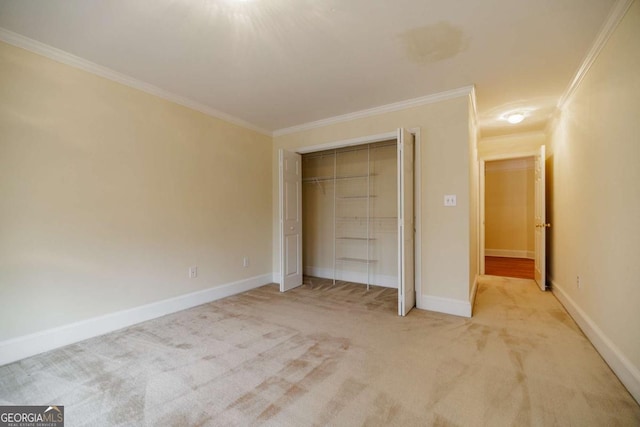 unfurnished bedroom featuring light colored carpet, baseboards, a closet, and ornamental molding