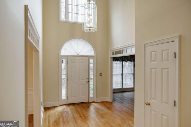 foyer with a notable chandelier, plenty of natural light, and a high ceiling