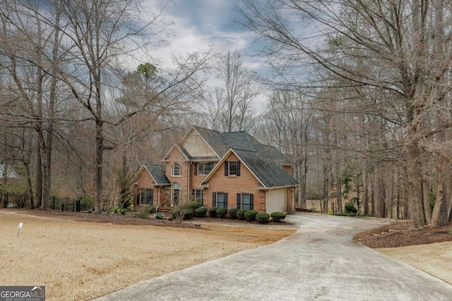 view of front of house featuring a garage, brick siding, and driveway