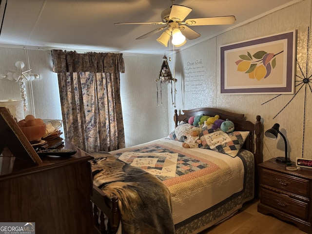 bedroom with a ceiling fan, wood finished floors, and crown molding