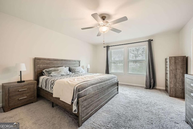 carpeted bedroom with ceiling fan and baseboards