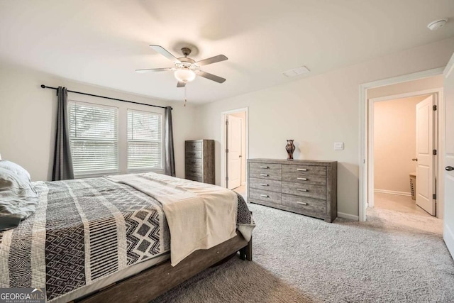 carpeted bedroom with ceiling fan and baseboards