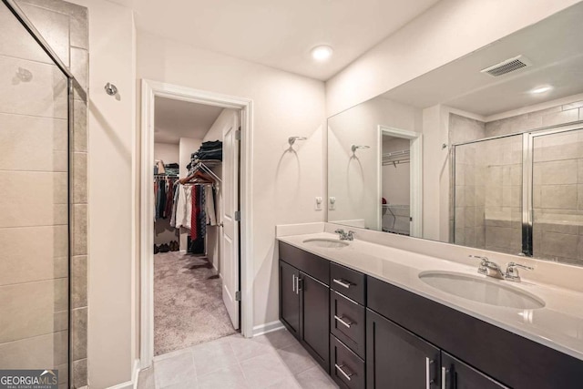 bathroom featuring a sink, visible vents, a shower stall, and tile patterned floors