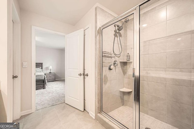 ensuite bathroom with connected bathroom, a shower stall, and tile patterned flooring