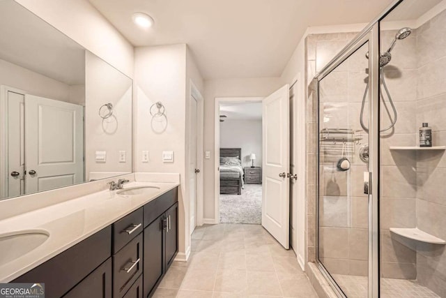 ensuite bathroom with double vanity, a shower stall, and a sink