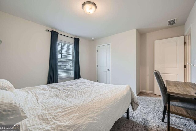 carpeted bedroom featuring visible vents and baseboards