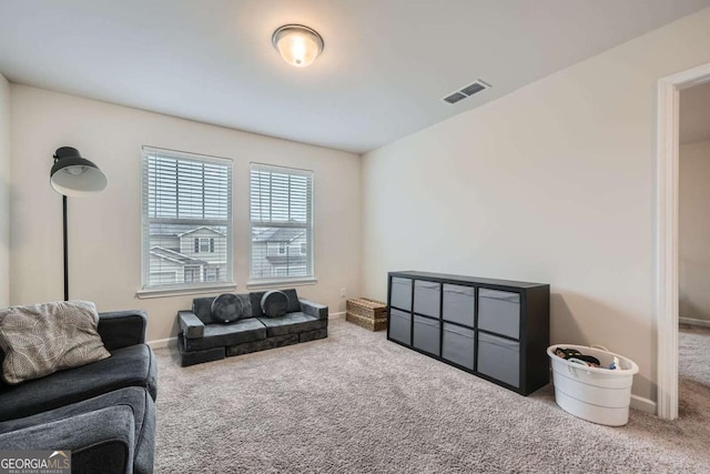 carpeted living room with visible vents and baseboards