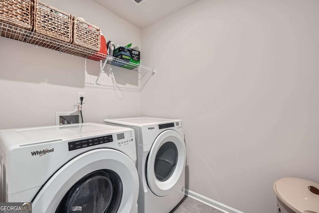 laundry area featuring tile patterned flooring, baseboards, laundry area, and washing machine and clothes dryer