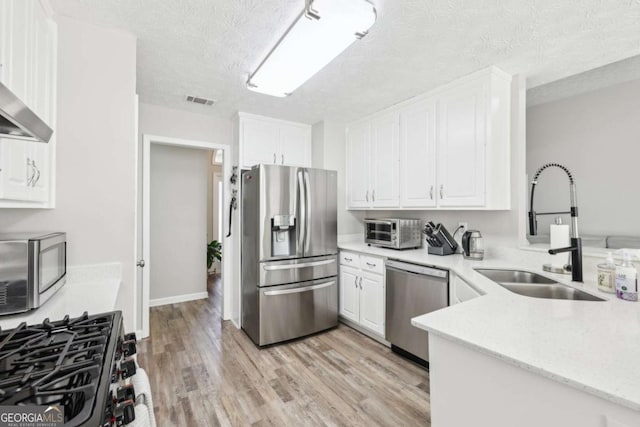 kitchen featuring white cabinetry, stainless steel appliances, and a sink