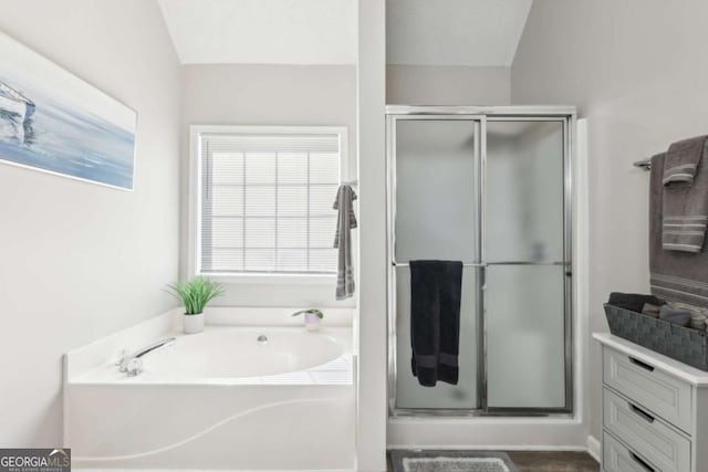 bathroom featuring a stall shower and a bath