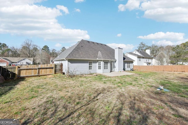 back of property with a yard, a patio, and a fenced backyard