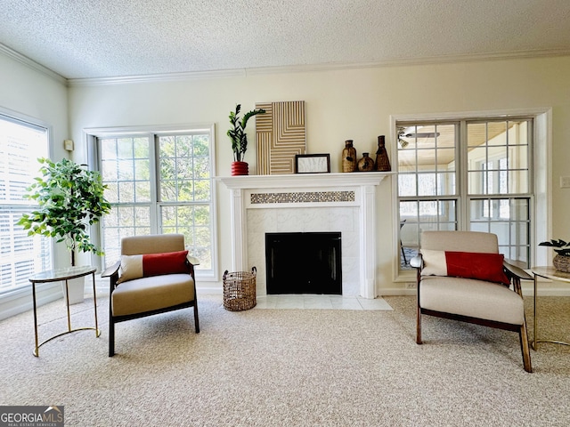 sitting room with a high end fireplace, a textured ceiling, crown molding, and carpet