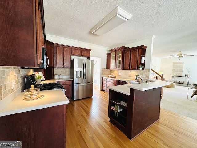 kitchen featuring light wood-style flooring, open shelves, a sink, stainless steel appliances, and a peninsula