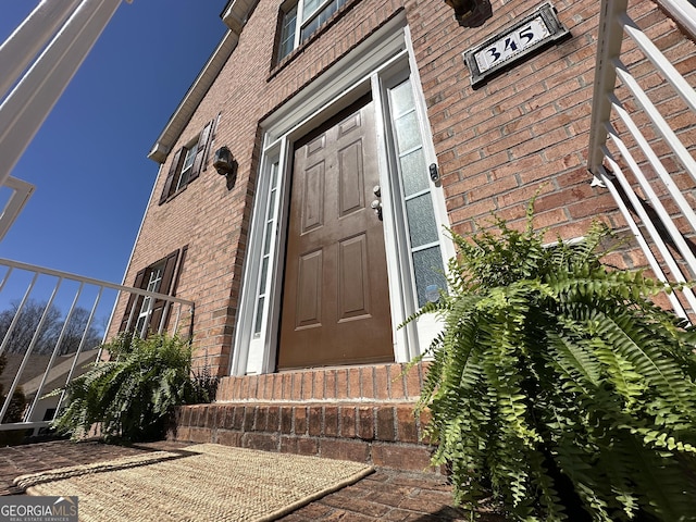 view of exterior entry with brick siding