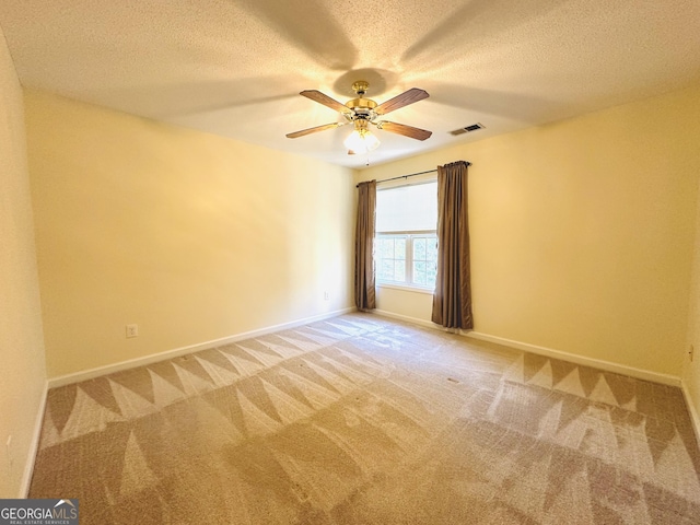 empty room with visible vents, baseboards, light colored carpet, and a textured ceiling