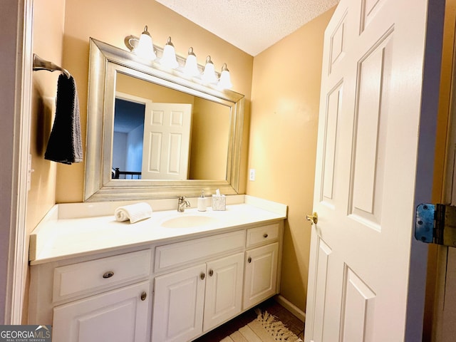 bathroom with a textured ceiling and vanity