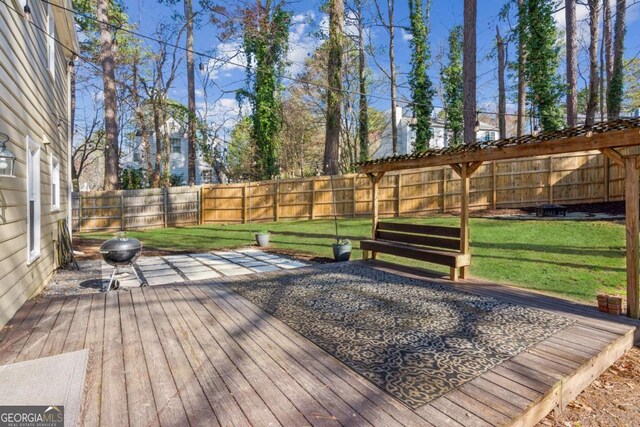 wooden deck featuring a lawn, a fenced backyard, and a grill