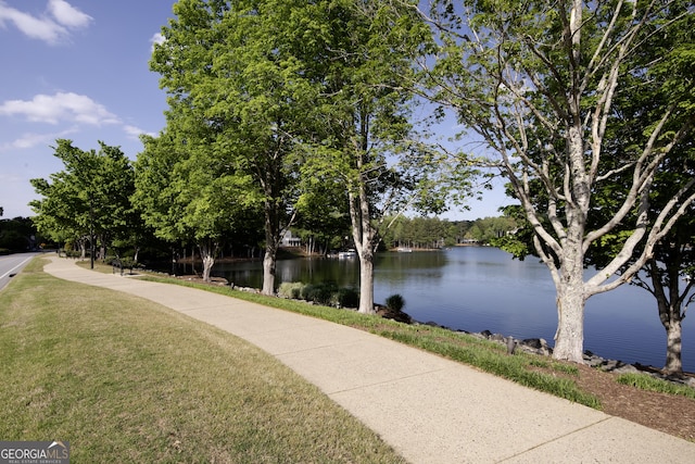 surrounding community with a lawn and a water view