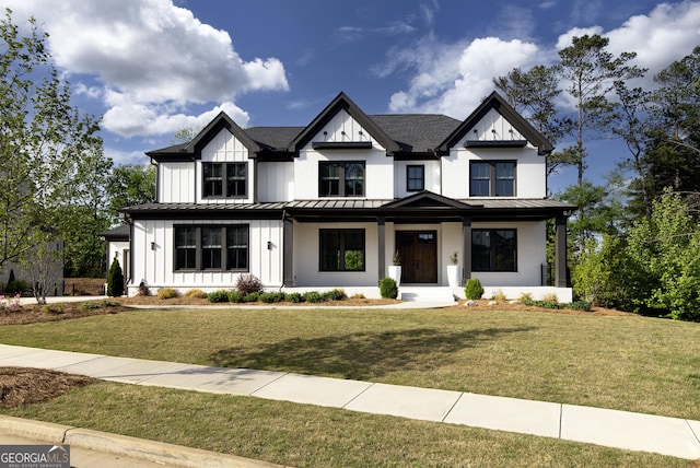 view of front of property featuring a standing seam roof, covered porch, board and batten siding, and a front yard