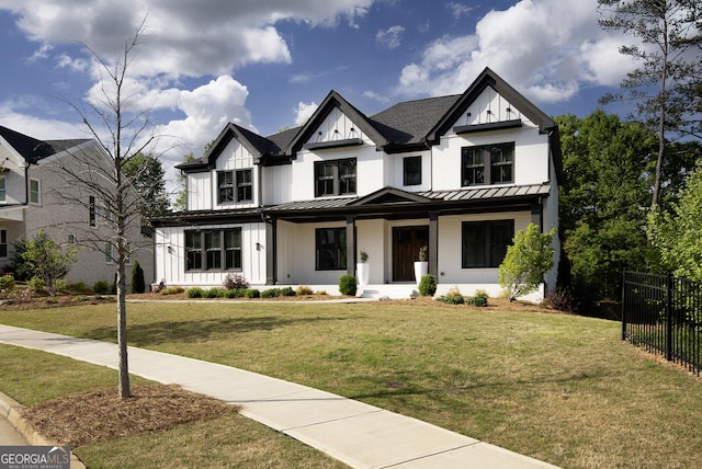 modern inspired farmhouse with a standing seam roof, covered porch, metal roof, fence, and board and batten siding