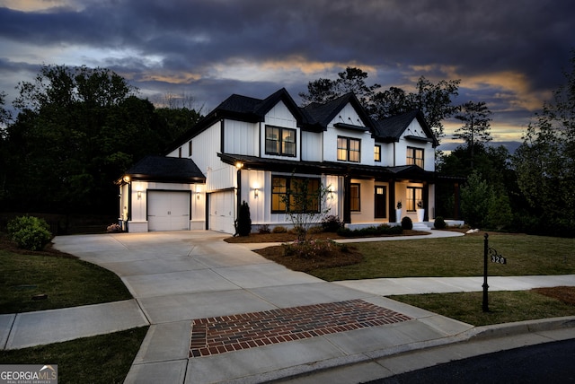 modern farmhouse featuring board and batten siding, a yard, driveway, and a porch