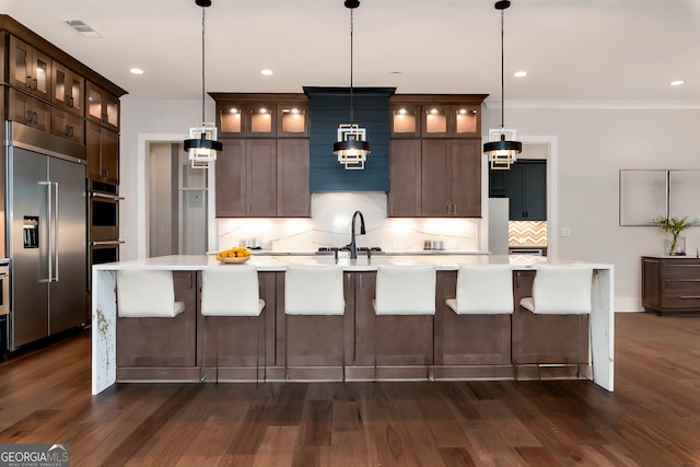 kitchen featuring visible vents, stainless steel appliances, light countertops, and a sink