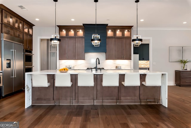 kitchen featuring a sink, light countertops, backsplash, appliances with stainless steel finishes, and visible vents