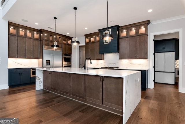 kitchen with dark brown cabinets, a sink, stainless steel appliances, backsplash, and dark wood-style flooring