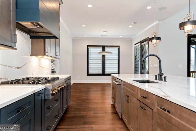 kitchen with a sink, stainless steel appliances, ornamental molding, and wall chimney range hood