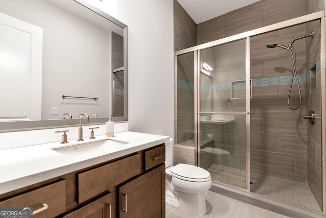 bathroom with a shower stall, toilet, and vanity