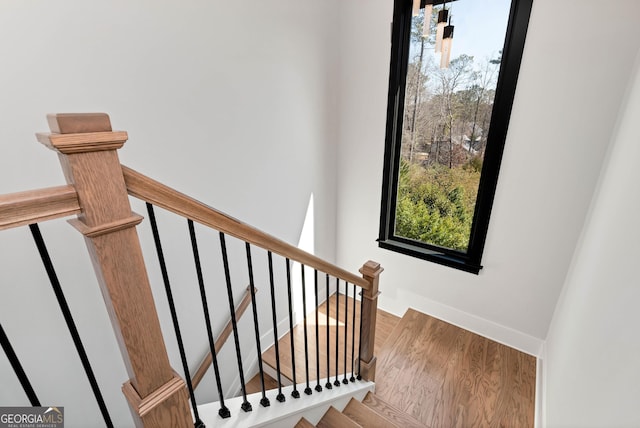 staircase featuring wood finished floors and baseboards