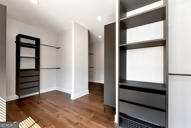 walk in closet with wood finished floors