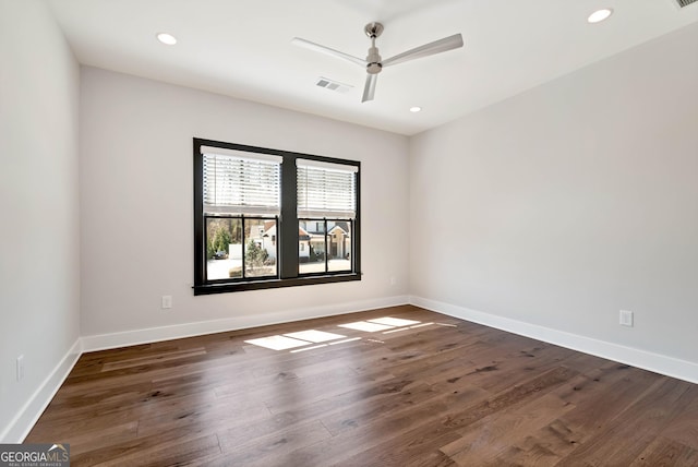 empty room with visible vents, a ceiling fan, baseboards, and dark wood-style flooring