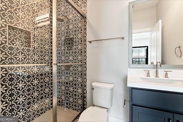 full bathroom featuring a shower stall, toilet, and vanity