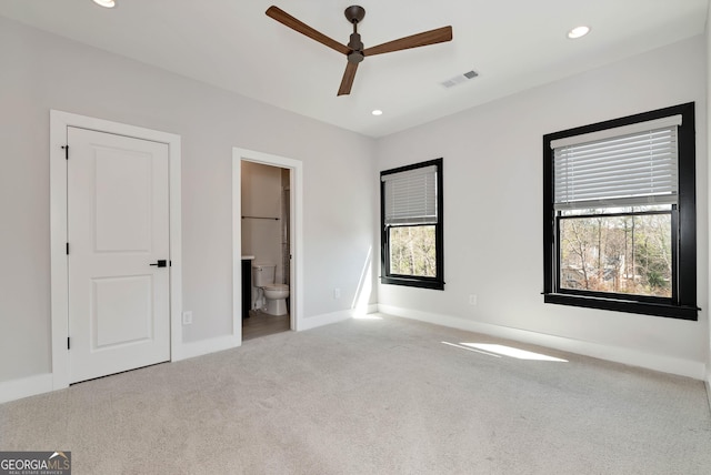 unfurnished bedroom featuring baseboards, visible vents, carpet, recessed lighting, and ensuite bath