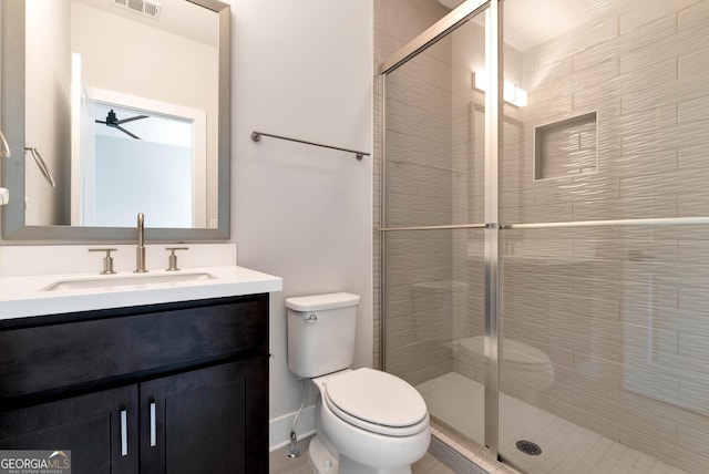 bathroom featuring visible vents, toilet, a stall shower, and vanity