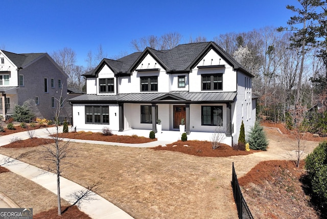 modern farmhouse featuring a porch, metal roof, and a standing seam roof