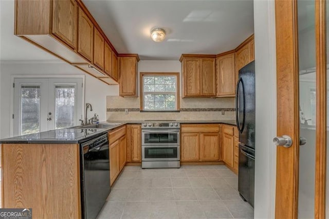 kitchen with decorative backsplash, a peninsula, french doors, black appliances, and a sink