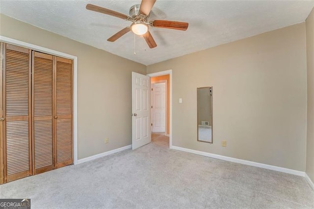 unfurnished bedroom with a closet, a textured ceiling, baseboards, and carpet floors