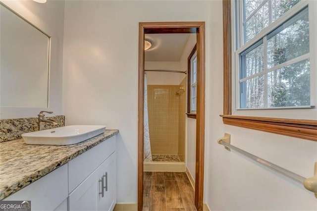 full bath featuring a shower stall, vanity, and wood tiled floor