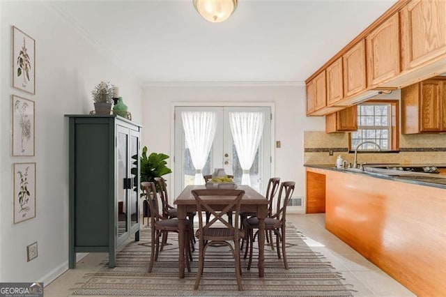 dining room with crown molding, light tile patterned flooring, french doors, and baseboards