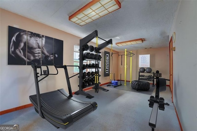 exercise room featuring baseboards and a textured ceiling