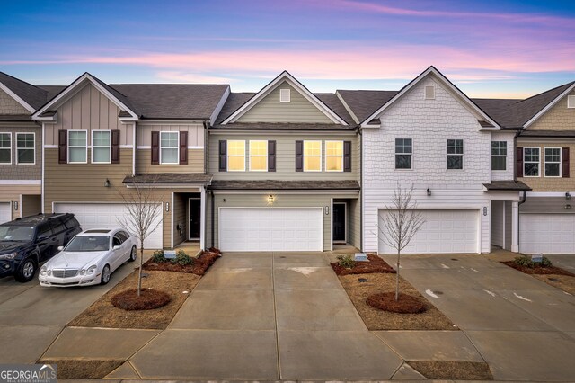 townhome / multi-family property featuring driveway, an attached garage, and board and batten siding